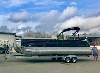 Slide: The Image of 2017 Misty Harbor SL-2685 pontoon boat on a trailer under a cloudy sky. - 0