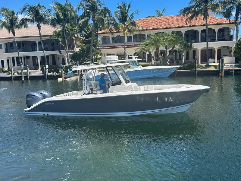 The Image of 2022 Pursuit S 288 boat cruising near waterfront homes. - 1