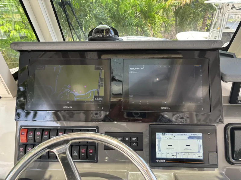 Slide: The Image of 2022 Pursuit S 288 boat dashboard with Garmin navigation screens and Yamaha display. - 12