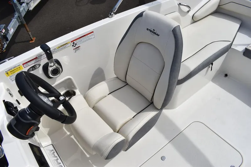 Slide: The Image of 2024 Stingray 182SC boat interior with white captain's seat and steering wheel. - 26