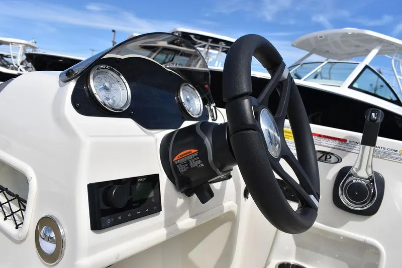 Slide: The Image of 2024 Stingray 182SC boat dashboard with steering wheel and control panel. - 33