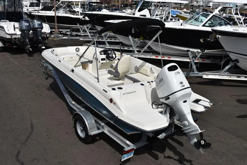 Slide: The Image of 2024 Stingray 182SC boat on trailer, docked among other boats. - 4