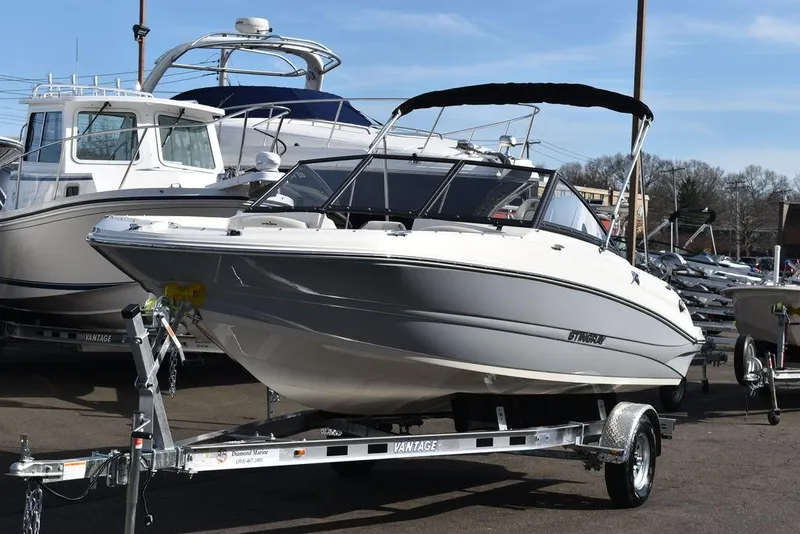 Slide: The Image of 2024 Stingray 191DC boat on a trailer at a marina. - 1