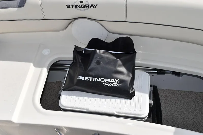 Slide: The Image of 2024 Stingray 191DC boat storage compartment with branded bag and cooler. - 16