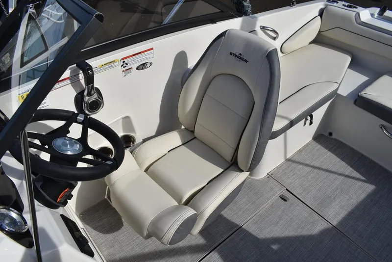Slide: The Image of 2024 Stingray 191DC boat interior with steering wheel and cushioned seating. - 18