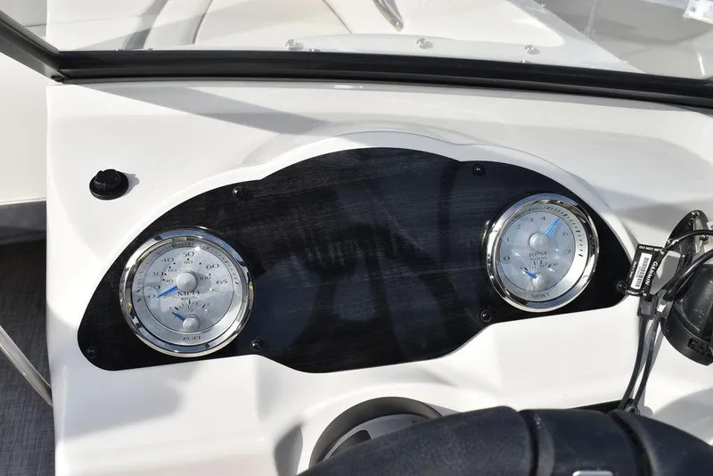 Slide: The Image of 2024 Stingray 191DC boat dashboard with dual gauges and steering wheel. - 22