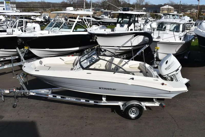 Slide: The Image of 2024 Stingray 191DC boat on a trailer, surrounded by other boats in a marina. - 3