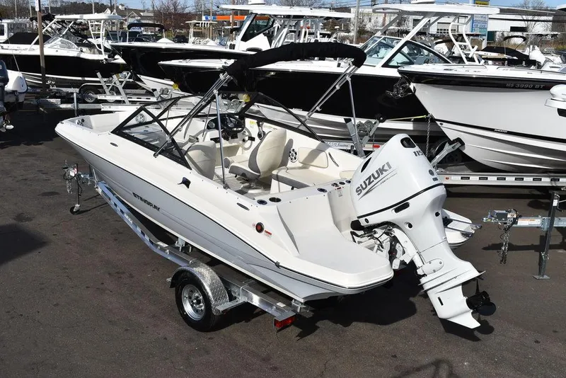 Slide: The Image of 2024 Stingray 191DC boat with Suzuki outboard motor on trailer in marina. - 4