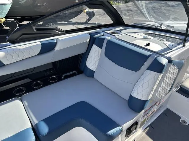 Slide: The Image of 2024 Malibu M220 boat interior with blue and white cushioned seating. - 10