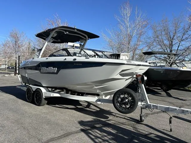 Slide: The Image of 2024 Malibu M220 boat on trailer in parking lot. - 3