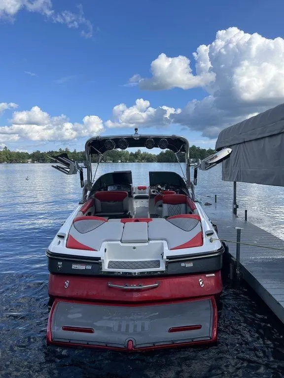 Slide: The Image of 2015 MasterCraft X55 boat docked on a lake under a blue sky. - 3