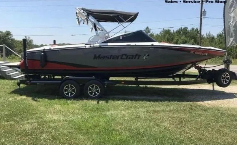Slide: The Image of 2015 MasterCraft X55 boat on a trailer, displayed outdoors. - 8