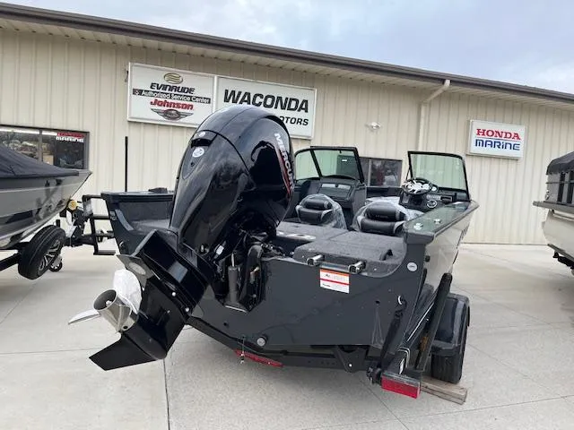 Slide: The Image of 2025 Lund 1875 Crossover XS boat displayed at dealership with Honda Marine engine. - 4