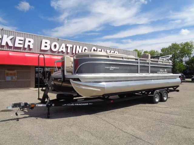 Slide: The Image of 2024 Sun Tracker Party Barge 24 DLX pontoon boat on trailer at boating center. - 2
