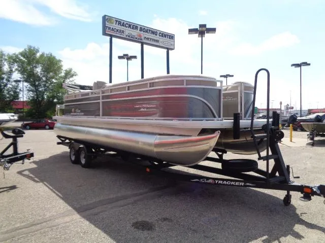 Slide: The Image of 2024 Sun Tracker Party Barge 24 DLX pontoon boat on trailer at dealership. - 3