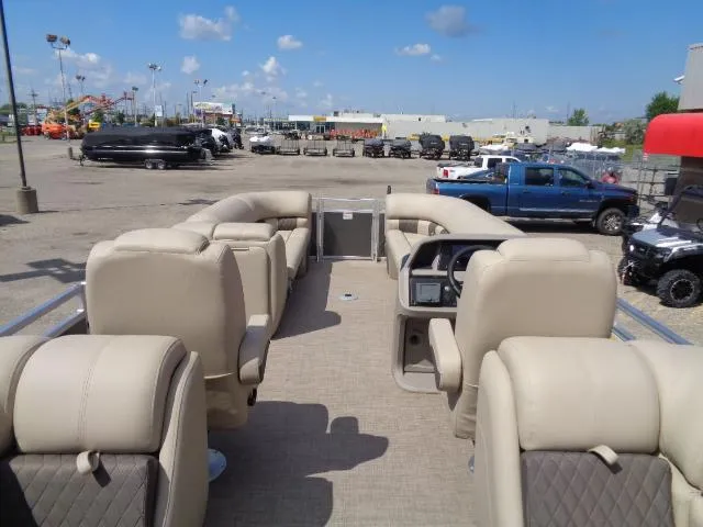 Slide: The Image of 2024 Sun Tracker Party Barge 24 DLX interior with beige seating in a parking lot. - 6