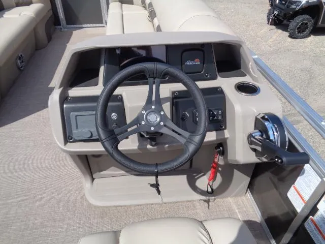 Slide: The Image of 2024 Sun Tracker Party Barge 24 DLX steering console with controls and cup holder. - 7