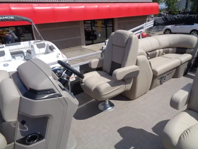 Slide: The Image of 2024 Sun Tracker Party Barge 24 DLX interior with plush seating and steering console. - 8
