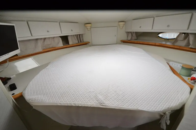 Slide: The Image of 1996 Wellcraft Portofino 43 cabin interior with bed, storage, and TV. - 11
