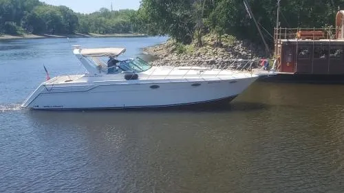 Slide: The Image of 1996 Wellcraft Portofino 43 yacht cruising on a serene river near lush greenery. - 26