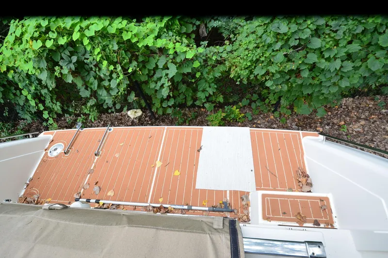 Slide: The Image of Deck of 1996 Wellcraft Portofino 43 boat with leaves and greenery. - 31