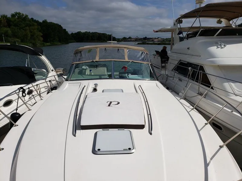 Slide: The Image of 1996 Wellcraft Portofino 43 yacht docked between two boats on a sunny day. - 4