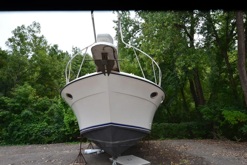 Slide: The Image of 1996 Wellcraft Portofino 43 boat on land, surrounded by lush green trees. - 6