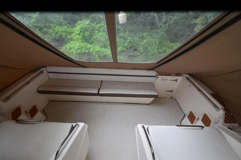 Slide: The Image of 1996 Wellcraft Portofino 43 interior with seating, beige upholstery, and large windows. - 8