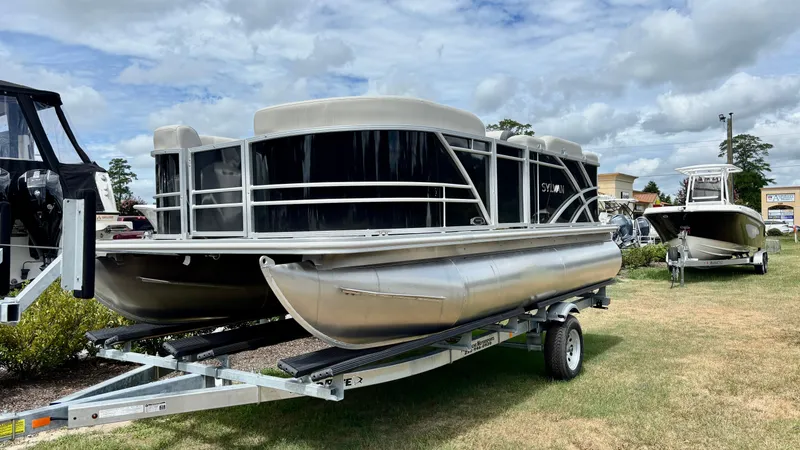 The Image of 2024 Sylvan 818 Mirage Cruise pontoon boat on trailer, displayed outdoors. - 3