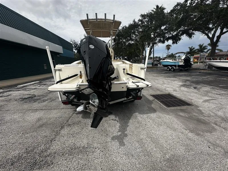 Slide: The Image of 2021 Scout 215 XSF boat with outboard motor, parked on a concrete surface. - 3