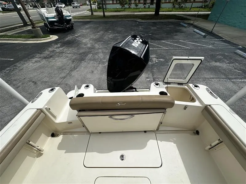 Slide: The Image of 2021 Scout 215 XSF boat with outboard motor in a parking lot. - 8