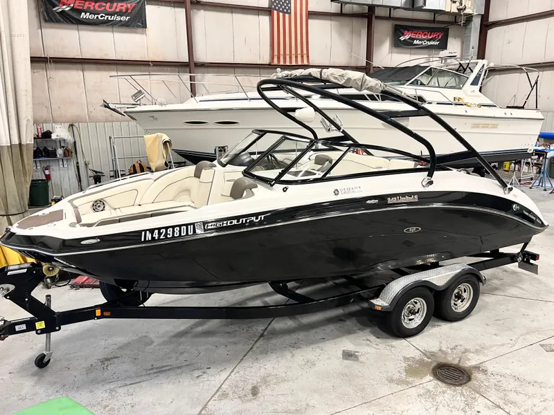 Slide: The Image of 2014 Yamaha Boats 242 Limited S in a showroom, black and white design, on a trailer. - 0