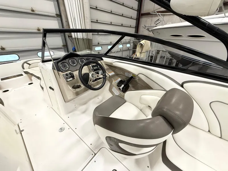 Slide: The Image of 2014 Yamaha Boats 242 Limited S interior with steering wheel and dashboard in a garage. - 13