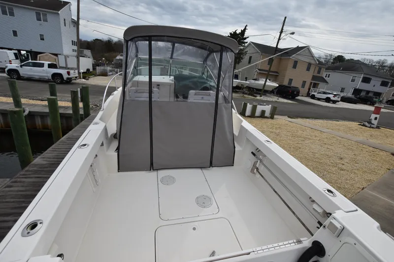 Slide: The Image of 1994 Pursuit 2350 boat with covered cockpit, docked in a residential marina. - 13