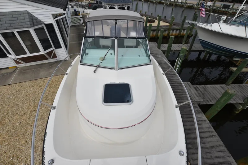 Slide: The Image of 1994 Pursuit 2350 boat docked at a marina, view of the bow and cabin. - 14