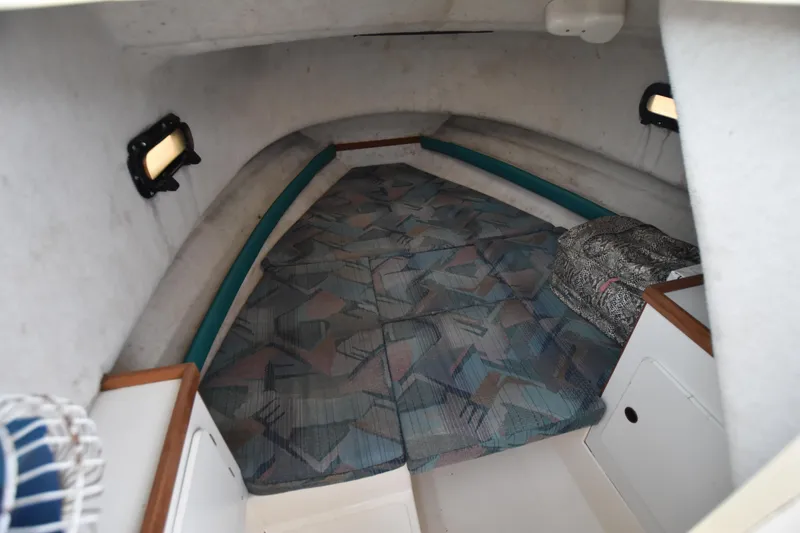 Slide: The Image of 1994 Pursuit 2350 boat cabin with cushioned sleeping area. - 18