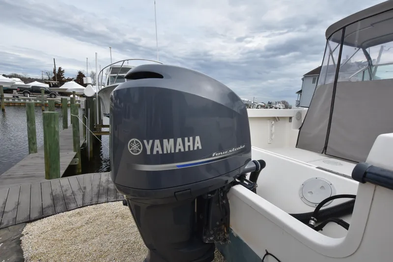 Slide: The Image of 1994 Pursuit 2350 boat with Yamaha outboard motor docked at marina. - 9