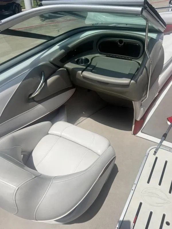 Slide: The Image of Interior of a 2016 Crownline Boats 21SS, featuring white leather seats and dashboard. - 11