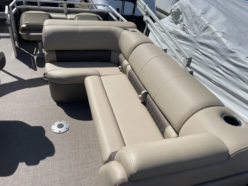 Slide: The Image of 2024 Sun Tracker Fishin' Barge 22 DLX interior seating area with beige upholstery. - 10