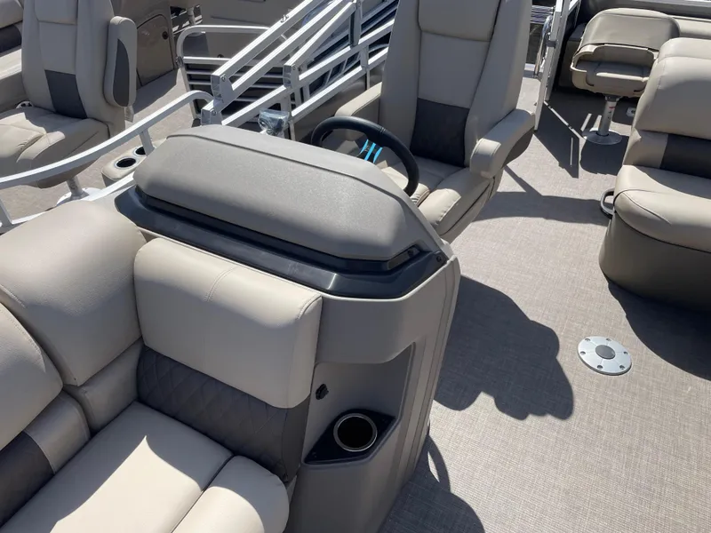 Slide: The Image of 2024 Sun Tracker Fishin' Barge 22 DLX interior with comfortable seating and steering console. - 12