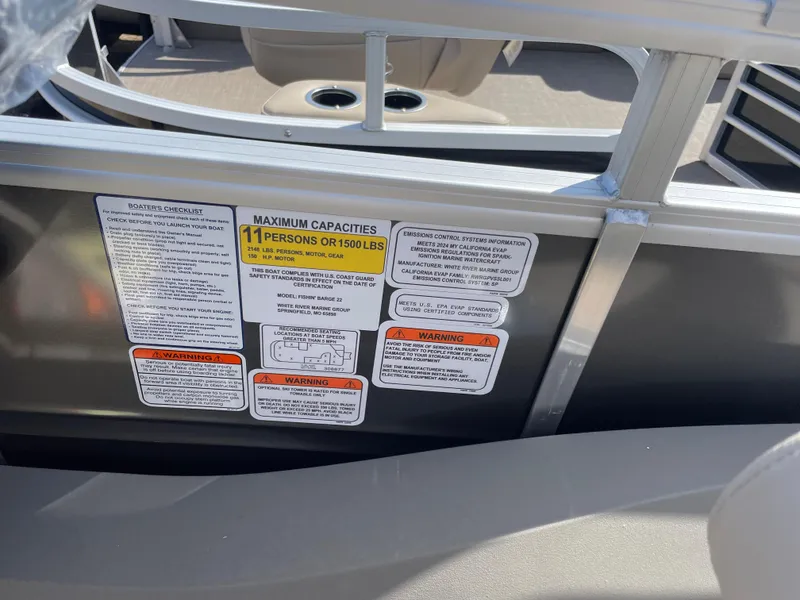 Slide: The Image of 2024 Sun Tracker Fishin' Barge 22 DLX capacity and safety labels on boat interior. - 13