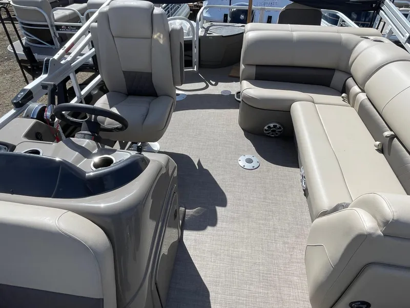 Slide: The Image of 2023 Sun Tracker SportFish 20 DLX pontoon boat interior with beige seating and steering console. - 8