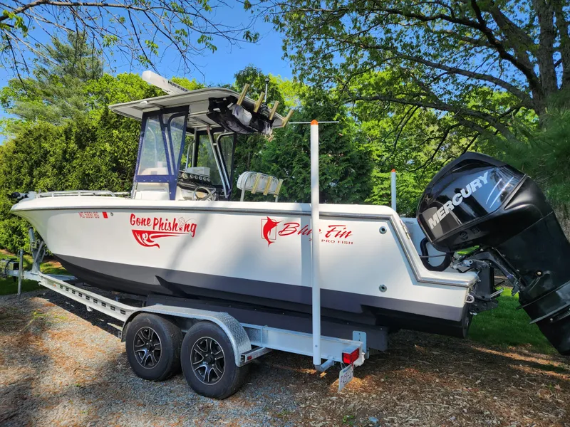 Slide: The Image of 2006 Blue Fin Pro Fish C/C boat on trailer with Mercury engine, parked outdoors. - 10