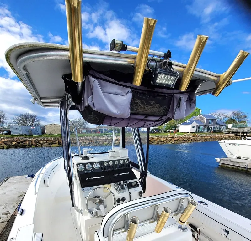 Slide: The Image of 2006 Blue Fin Pro Fish C/C boat with rod holders and control panel, docked by the water. - 4
