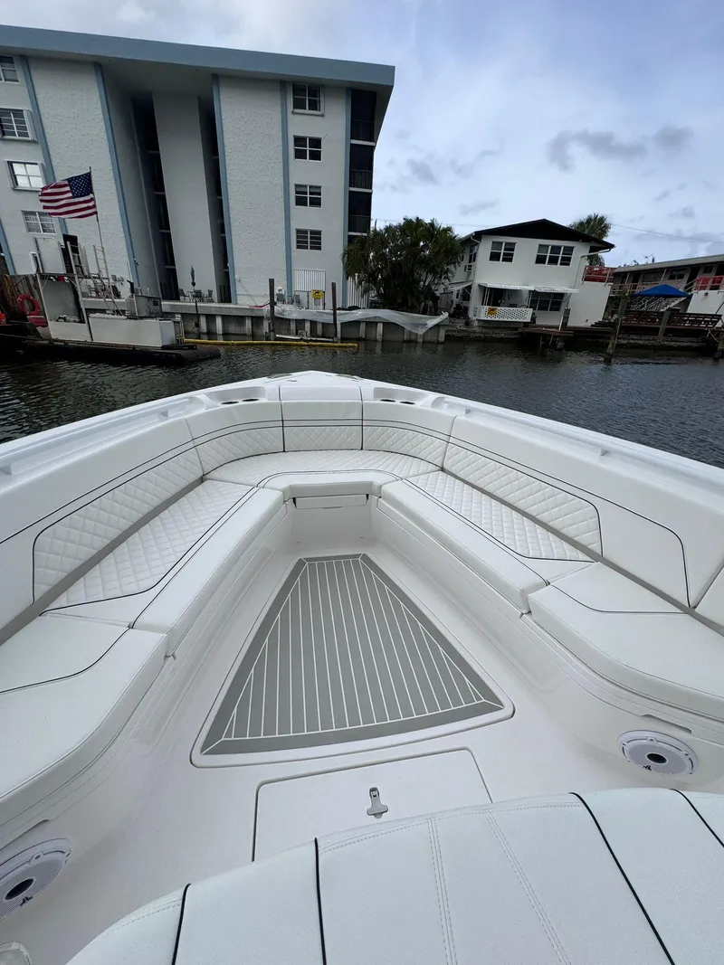 Slide: The Image of 2023 Intrepid 427 Nomad FE boat docked near waterfront buildings. - 13