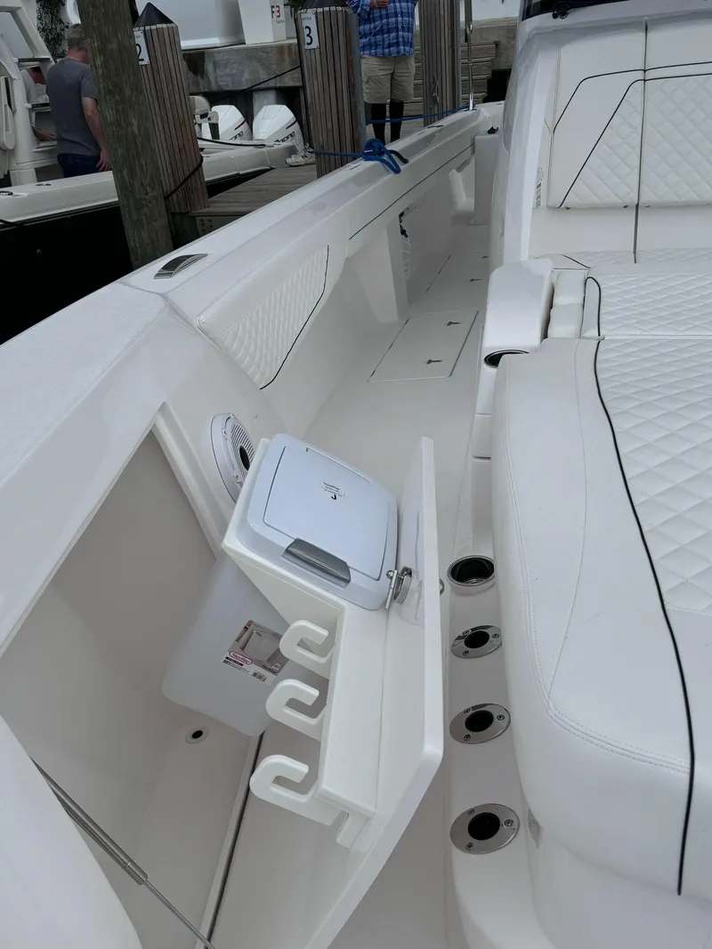 Slide: The Image of 2023 Intrepid 427 Nomad FE boat interior with white seating and storage compartments. - 17