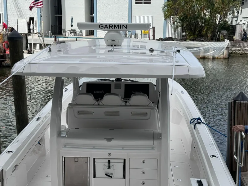 Slide: The Image of 2023 Intrepid 427 Nomad FE boat docked, featuring Garmin navigation system. - 2