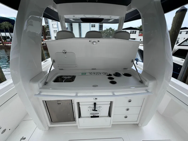Slide: The Image of 2023 Intrepid 427 Nomad FE boat interior with open storage compartments and sink. - 8