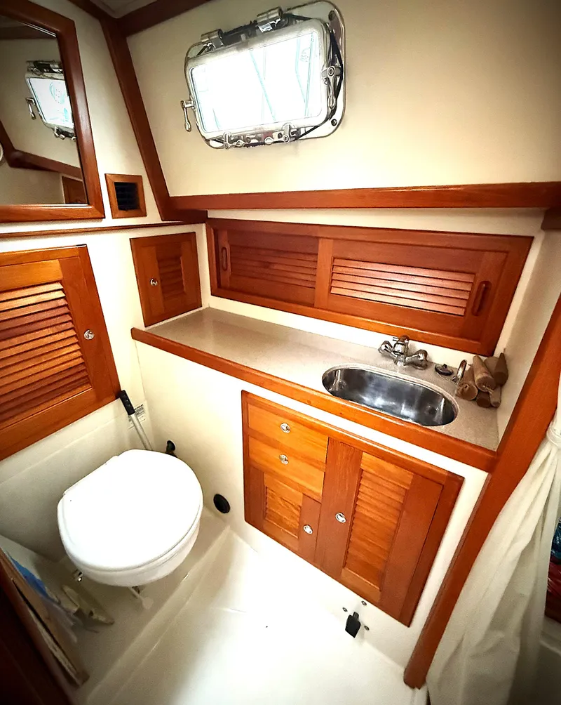 Slide: The Image of 2005 Pacific Seacraft 40 yacht bathroom with wooden cabinets and stainless steel sink. - 10