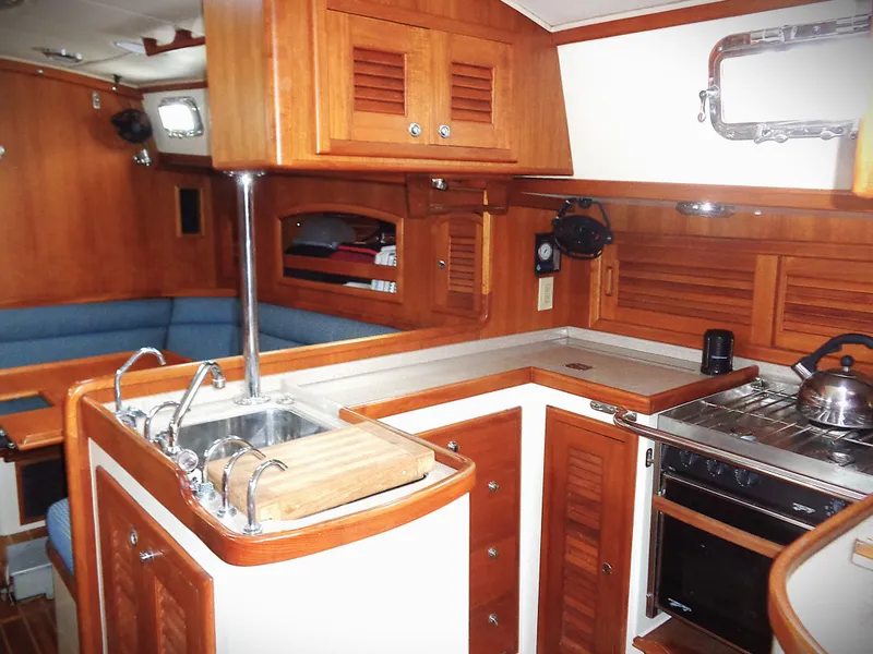Slide: The Image of Interior of 2005 Pacific Seacraft 40 sailboat with wooden cabinetry and compact kitchen. - 7